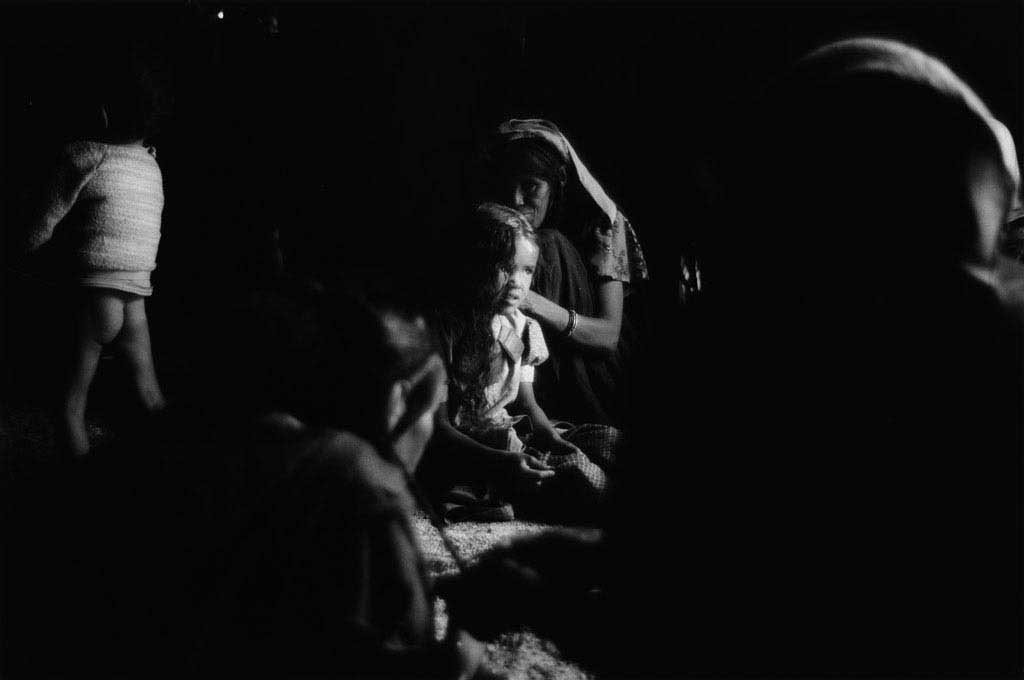 Les femmes et filles d'Ezarnen se sont réunies dans l'akabar de Raïcha. Demain, c'est l'Aïd. Les femmes se sont lavées au point d'eau dans le désert et sont en train de se coiffer mutuellement. Raïcha coiffe sa plus jeune fille. Tassili du Hoggar, Sahara algérien, 1993