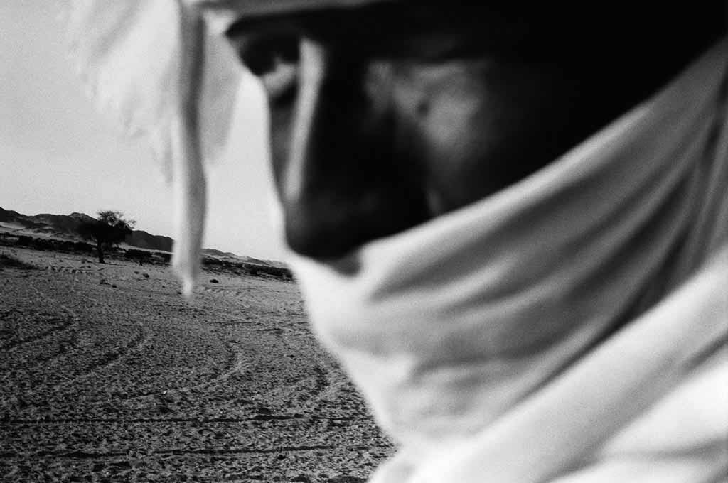 Atayeb partage sa vie entre la ville de Djanet et un campement semi-nomade dans l'Oued Essendilène où habite encore sa famille. Il fait le chemin entre Djanet et le campement encore à chameau, alors que beaucoup de Touaregs ont abandonné les chameaux pour les 4x4. Sahara algérien, 1997